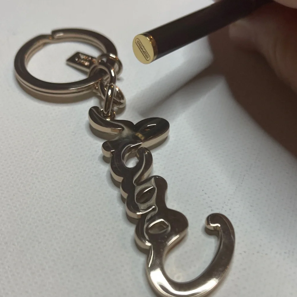 Coach Gold Rhinestone Keychain with a Black Coach Pen